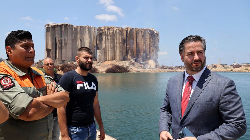 Lebanese Minister of Economy Amin Salam (R) vists the port of the capital Beirut, as a corner of the silos which were destroyed in a massive explosion on August 4, 2020, burns on July 14, 2022. - The fire at the port's blast-hit grain silos, at risk of collapse due to severe damage, ignited at the start of the month because of fermentation of remaining grain stocks paired with rising temperatures. (Photo by ANWAR AMRO / AFP) (Photo by ANWAR AMRO/AFP via Getty Images)