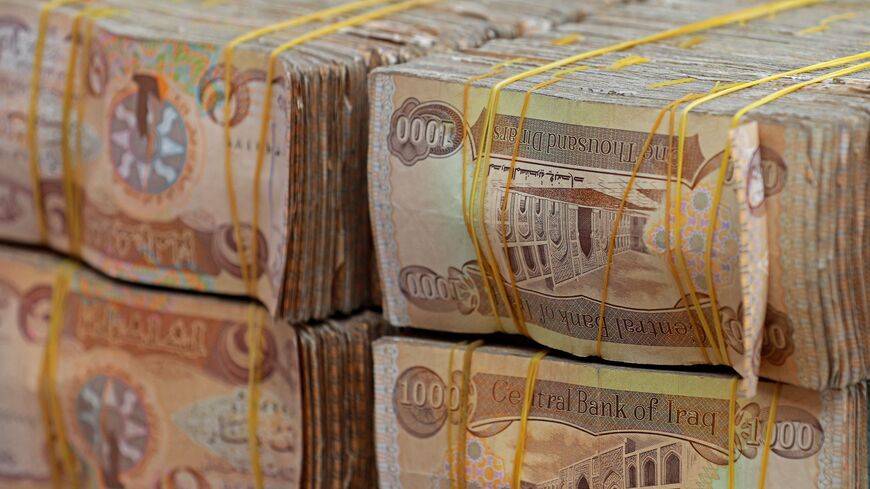 Stacks of Iraqi dinars are seen at currency exchange shop in Baghdad on February 14, 2023. - Iraq nudged up the value of its local currency against the dollar in an effort to stabilise the dinar after tougher foreign transfer regulations sent its value fluctuating. The government adopted a new official exchange rate, fixing it at 1,300 dinars to the US dollar instead of 1,470, the prime minister's office said. (Photo by Murtaja LATEEF / AFP) (Photo by MURTAJA LATEEF/AFP via Getty Images)