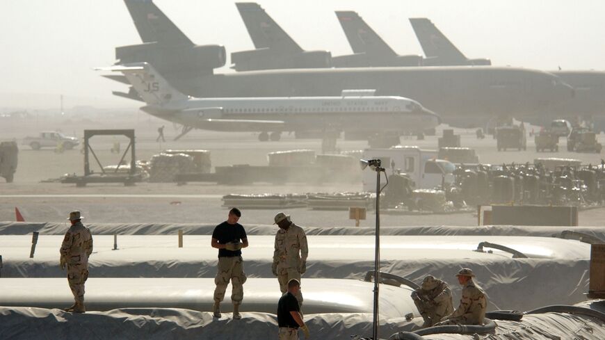 Members of the Petroleum Oils and Lubricants squadron at the 379th Air Expeditionary Wing take a break from replacing a 50,000-gallon fuel bladder in support of Operation Enduring Freedom, on Dec. 30, 2002, in Al Udeid, Qatar.