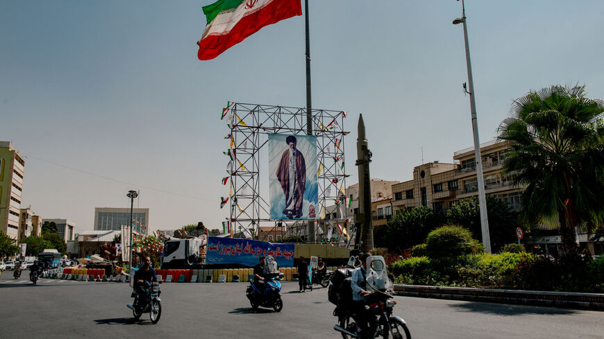 Iranian motorcyclist pass by a banner of Iran's Supreme Leader Ayatollah Ali Khamenei, placed next to a ballistic missile in Baharestan Square in Tehran, Iran, on September 26, 2024 on the sideline of an exhibition which marks the 44th anniversary of the start of Iran-Iraq war.