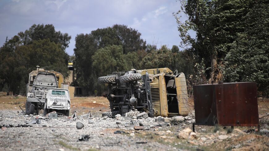 Debris and military vehicles lie at the scene of an Israeli strike in Syria's southern Hama governorate on April 3, 2025.