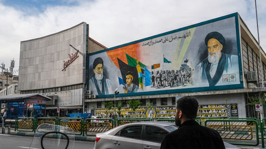 Iranians pass by a mural that depicts the two Supreme Leaders of Iran near Enghelab (Revolution) Square in downtown Tehran, Iran on April 8, 2025. (AFP via Getty Images)