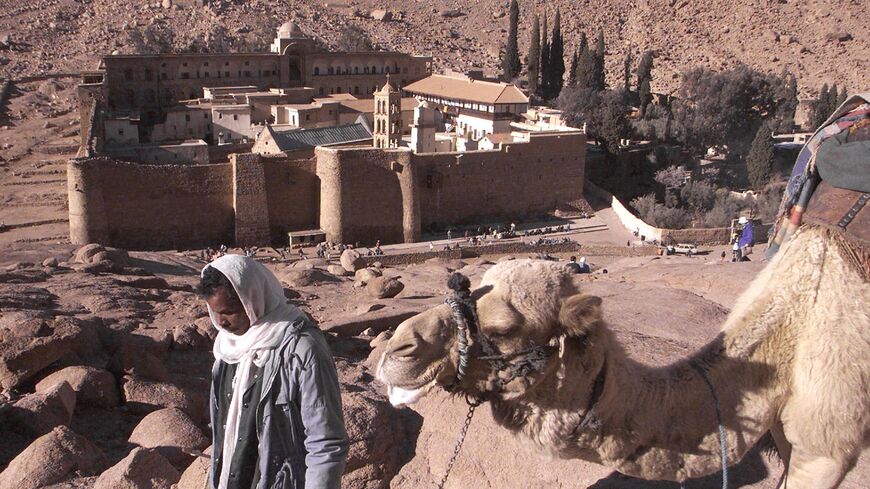 An Egyptian Bedouin walks with his camel on Feb. 24, 2000, outside the walls of Saint Catherine's Monastery in the Sinai Peninsula, some 400 kilometers southeast of Cairo.