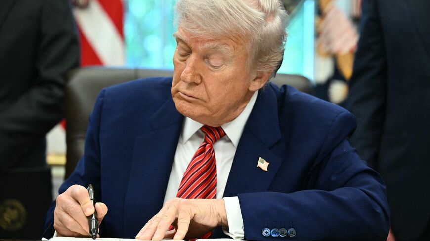 US President Donald Trump signs executive orders in the Oval Office of the White House in Washington, DC, on May 23, 2025. 