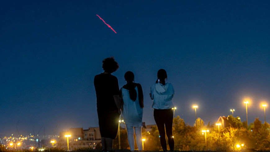 Israeli-Airstrikes-in-Tehran People gather on a hill to watch as Iran's air defense systems fire shots aimed at Israeli drones in the sky of Tehran, Iran, on June 14, 2025. Iran's foreign minister said the country would respond "decisively and proportionally" to a wave of attacks that Israel launched beginning in the early hours of June 13. The attacks targeted multiple military, scientific and residential locations, as well as senior government officials. (Photo by Khoshiran / Middle East Images via AFP) (