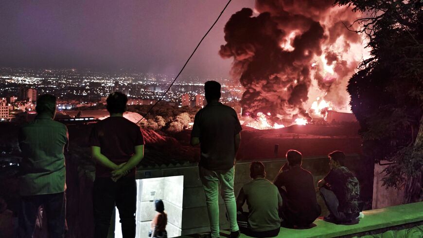 TEHRAN, IRAN - JUNE 15: People observe fire and smoke from an Israeli attack on the Shahran oil depot on June 15, 2025 in Tehran, Iran. Iran's foreign minister said the country would respond "decisively and proportionally" to a wave of attacks that Israel launched beginning in the early hours of June 13. The attacks targeted multiple military, scientific and residential locations, as well as senior government officials. (Photo by Stringer/Getty Images)