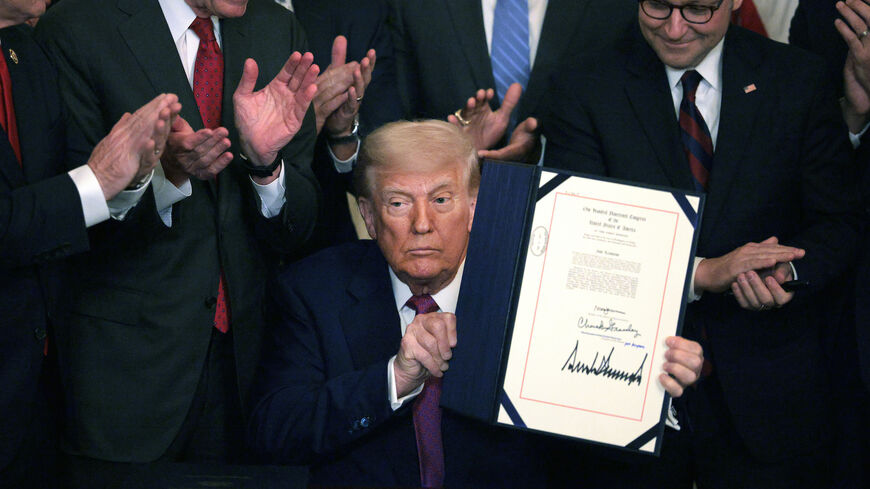 President Donald Trump, joined by Sen. John Barrasso (R-WY), Speaker of the House Mike Johnson (R-LA) and other lawmakers, holds up an executive order after signing a series of bills related to California’s vehicle emissions standards during an event in the East Room of the White House on June 12, 2025 in Washington, DC.