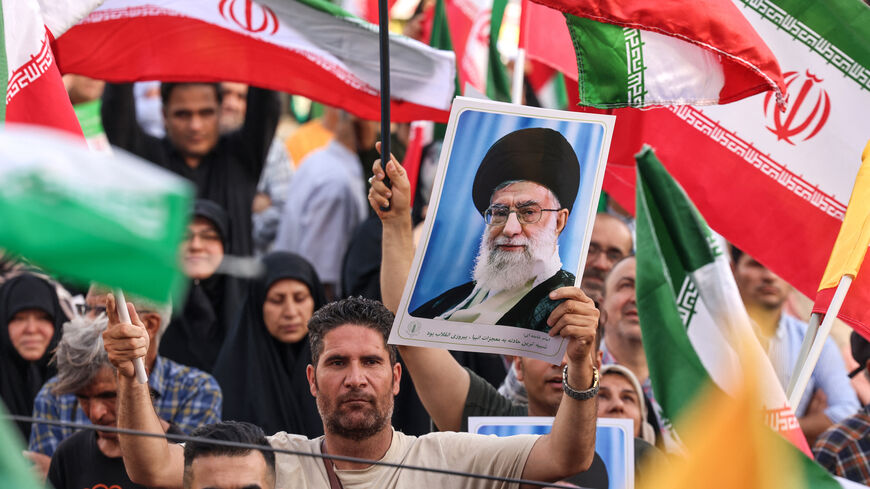 An Iranian man holds a portrait of supreme leader Ayatollah Ali Khamenei as people celebrate a ceasefire between Iran and Israel at Enghlab Square in the capital Tehran on June 24, 2025.
