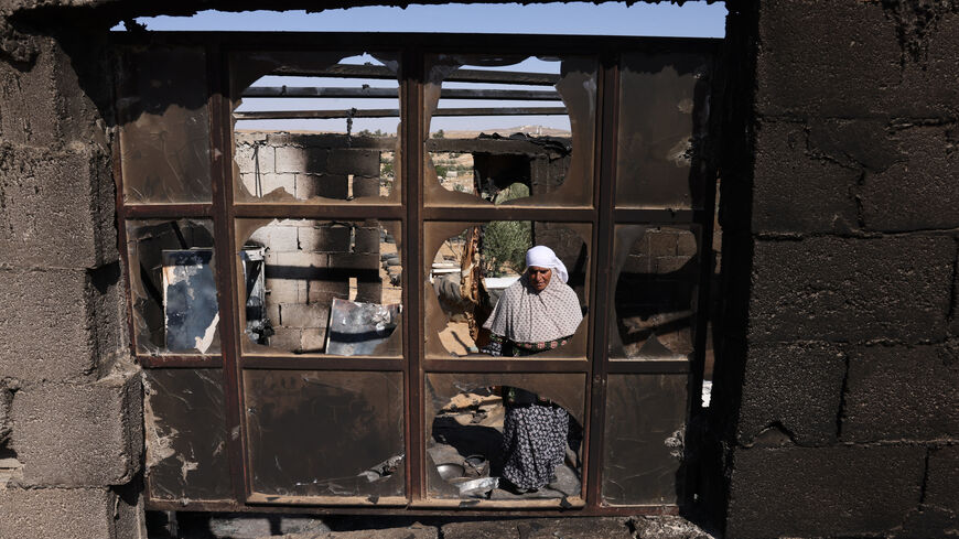 Palestinian Fawzya Ishreiteh clears burnt belongings in the living and kitchen area of her family house after a reported attack overnight by Israelis from a nearby settlement, in Susya south of Hebron city in the occupied West Bank on June 25, 2025. Israel has occupied the West Bank since 1967, and violence there has soared since the start of the Gaza war in 2023. The West Bank is home to about three million Palestinians, but also some 500,000 Israelis living in settlements that are illegal under internatio