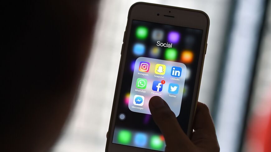 This photo taken on March 22, 2018, shows a woman looking at social networking applications on a smartphone in Kuala Lumpur.