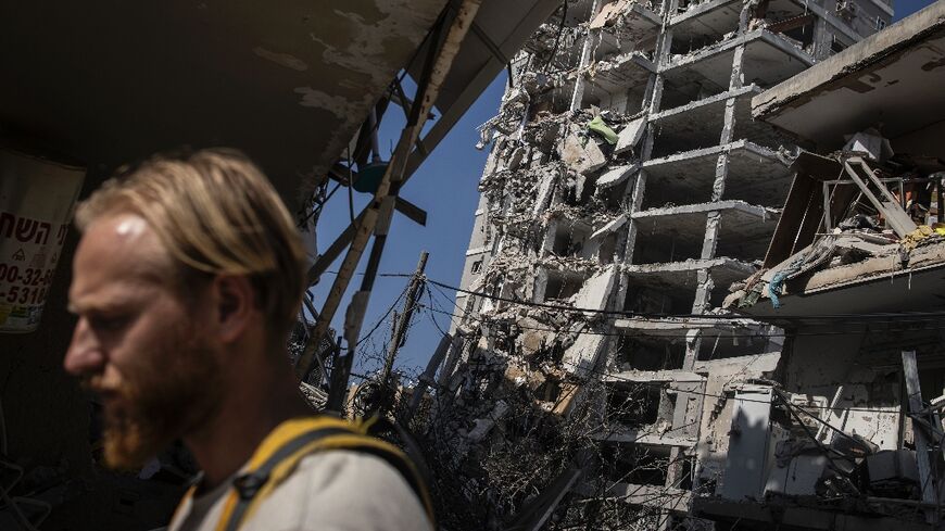 A man walks past a heavily damaged building following an overnight Iranian missile strike in Bat Yam, central Israel