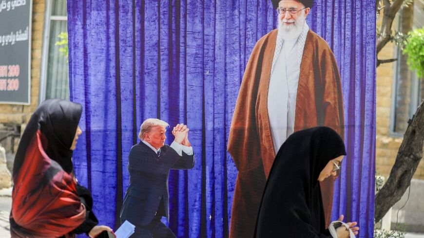 A poster depicting US President Donald Trump prostrating in front of Iran's Ayatollah Ali Kamenei hangs in a southern Beirut suburb