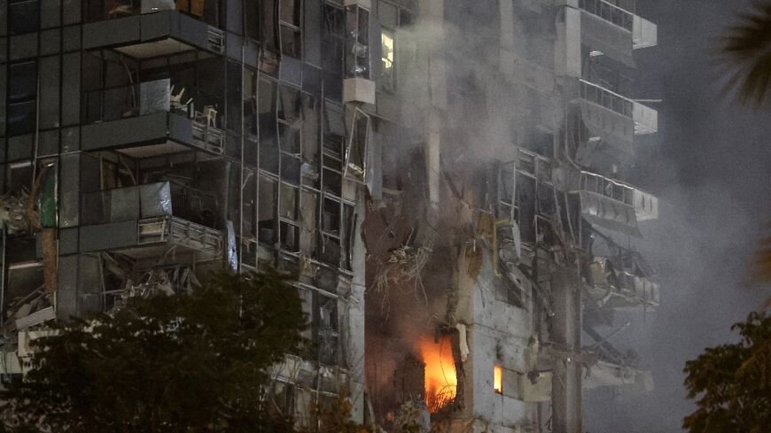 Fire and smoke rise from a building, reportedly hit by a missile fired from Iran, in Tel Aviv