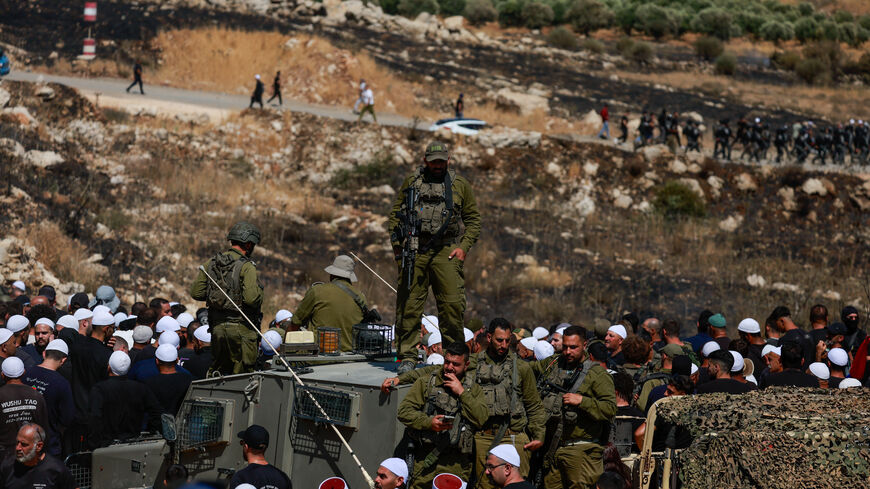 An Israeli soldier stands on a vehicle as Israeli Druze cross the border to check on their family members in Syria, amid the ongoing conflict in the Druze areas in Syria, in Majdal Shams, near the ceasefire line between the Israeli-occupied Golan Heights and Syria, July 16, 2025. REUTERS/Ammar Awad