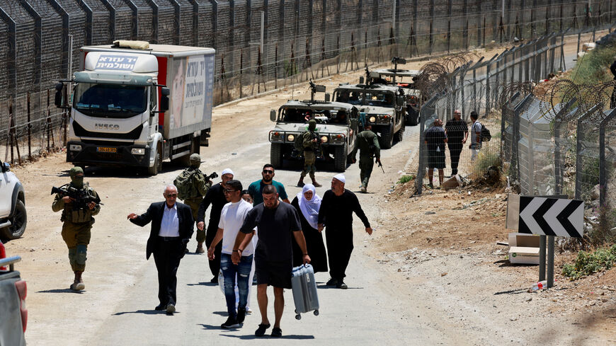 Syrian people are escorted by the Israeli military as they walk from Majdal Shams back to Syria, along the ceasefire line between the Israeli-occupied Golan Heights and Syria, amid the ongoing conflict in the Druze areas in Syria, in Majdal Shams, July 17, 2025. REUTERS/Ammar Awad