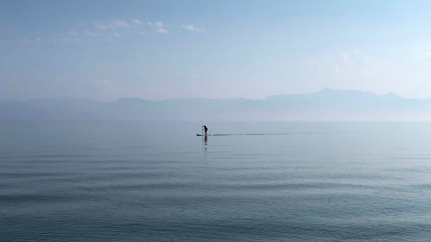 FILE PHOTO: A man paddles in the waters of the Ionian Sea near Sidari settlement on the island of Corfu, Greece July 26, 2019. REUTERS/Vasily Fedosenko/File Photo
