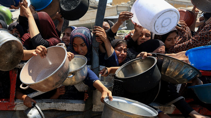 Palestinians gather to receive food from a charity kitchen, amid a hunger crisis, in Gaza City, July 22, 2025. REUTERS/Dawoud Abu Alkas