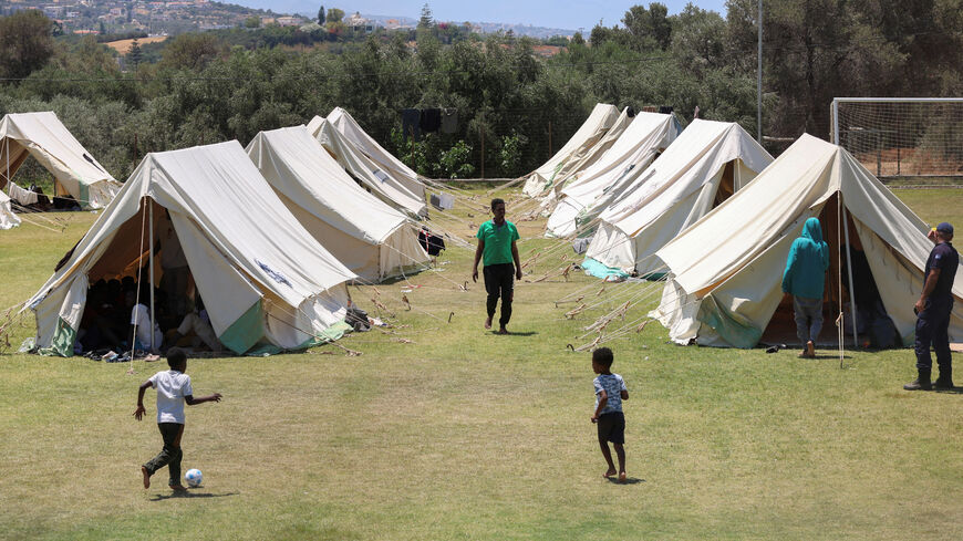 FILE PHOTO: Children play by the tents, as recently arrived migrants shelter at the temporary migrants' camp staged on a soccer pitch in the region of Rethymno in Crete island, Greece, June 24, 2025. REUTERS/Stefanos Rapanis/File Photo