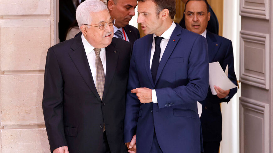 French President Emmanuel Macron speaks with Palestinian President Mahmoud Abbas as they walk to a meeting at the Elysee Presidential Palace in Paris, France July 20, 2022. Ludovic Marin/Pool via REUTERS/File Photo