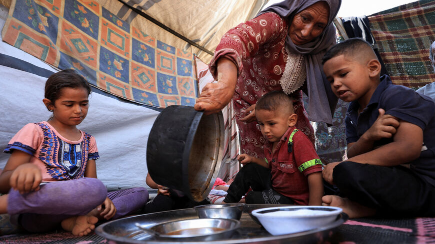 Nemah Hamouda prepares food for her grandchildren using limited ingredients, amid a critical shortage of infant formula and widespread malnutrition, in Gaza City, July 29, 2025. REUTERS/Dawoud Abu Alkas