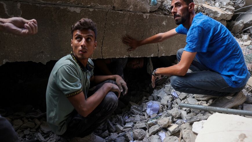 Palestinians look for survivors after an Israeli strike on Gaza City