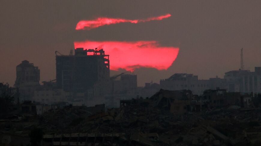 The sun sets behind destroyed buildings in the besieged Palestinian territory of Gaza on July 3, 2025