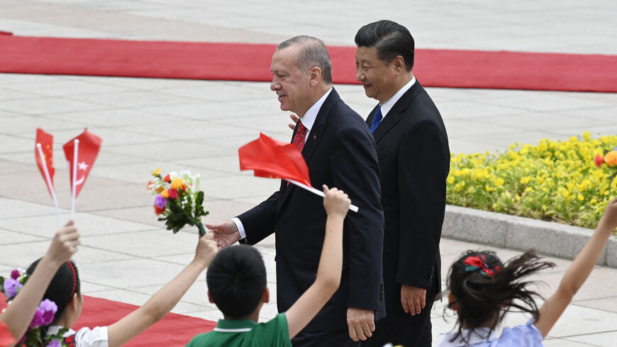 Turkish President Recep Tayyip Erdogan (L) is welcomed by a group of children as he inspects Chinese honour guards with Chinese President Xi Jinping (R) during a welcome ceremony outside the Great Hall of the People in Beijing on July 2, 2019. (Photo by WANG ZHAO / AFP) (Photo by WANG ZHAO/AFP via Getty Images)