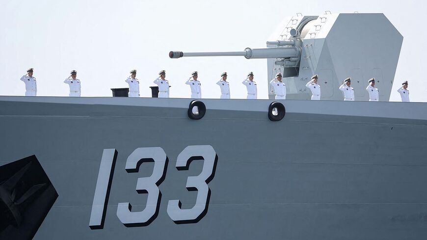 This handout photo made available by the Iranian Army Office on March 12, 2025, shows navy personnel saluting aboard a Chinese military ship during a joint Iranian-Russian-Chinese drill in the Gulf of Oman.