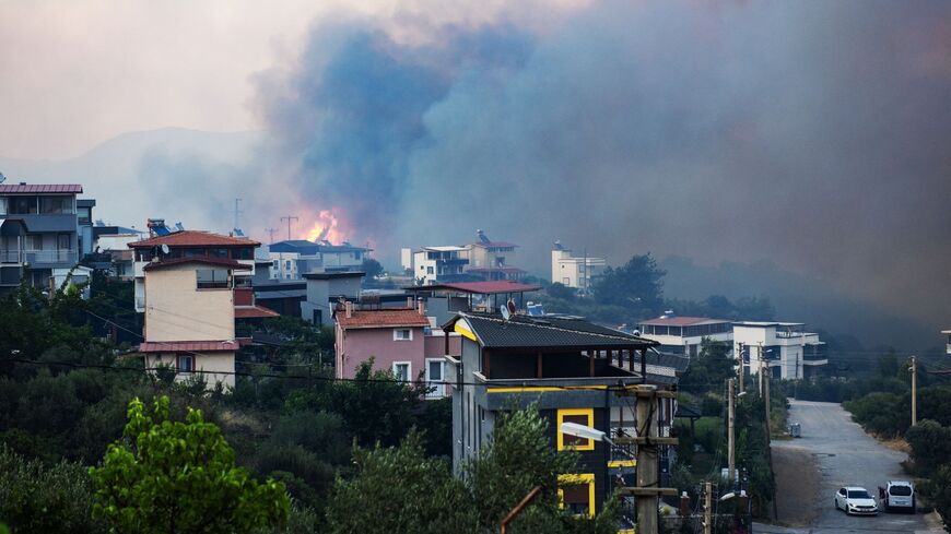Smoke and flames rise from a forested area following a wildfire in the Seferihisar district of Izmir, Turkey, June 30, 2025.
