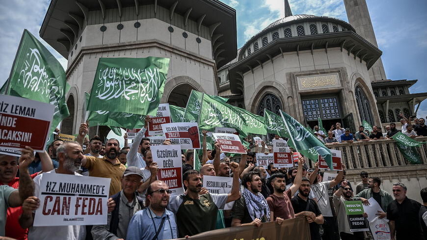 Protesters hold placards as they demonstrate against cartoonists of a satirical magazine following allegations that it had published a cartoon of the Prophet Mohammed, outside Taksim mosque in Istanbul on July 1, 2025.