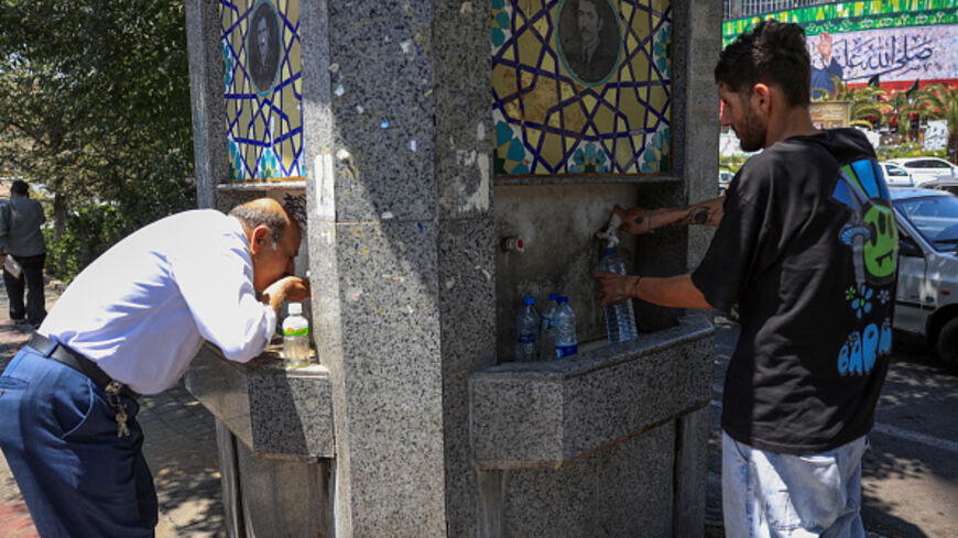 Iranians drink water from a public street fountain amid soaring temperatures in Tehran on July 22, 2025. (AFP via Getty Images)