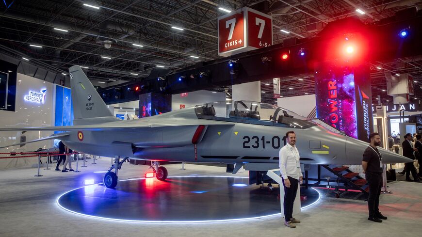 People pose for photographs in front of a Turkish Hurjet at the 17th International Defense Industry Fair (IDEF), Istanbul, July 24, 2025.