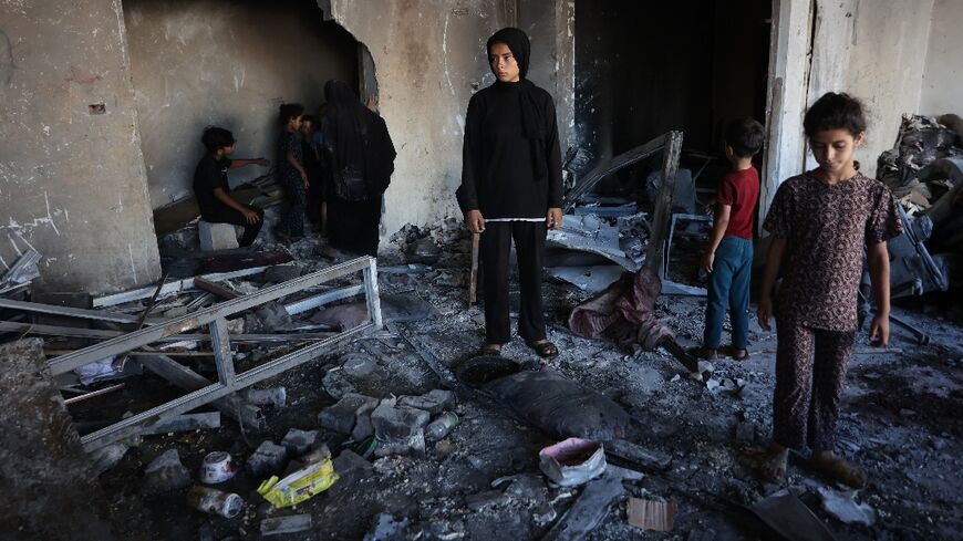 People inspect the damage after a reported Israeli strike on a clinic-turned-shelter in the  Al-Rimal neighborhood of Gaza City