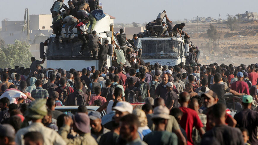 Palestinians climb onto trucks as they seek aid supplies in Khan Younis, southern Gaza Strip, August 4, 2025. REUTERS/Hatem Khaled