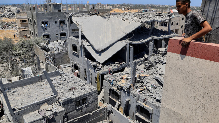 FILE PHOTO: A Palestinian inspects the damage on houses destroyed during an Israeli military operation, in Deir al-Balah, central Gaza Strip, July 23, 2025. REUTERS/Hatem Khaled/File Photo