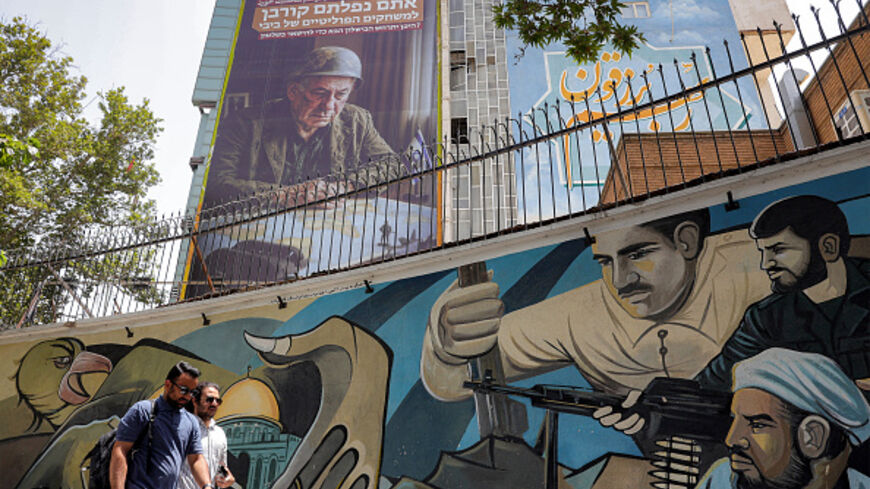 Pedestrians walk past a mural at Palestine Square in central Tehran on July 8, 2025, as an anti-Israeli billboard is displayed on the facade of a building depicting the Israeli prime minister Benjamin Netanyahu with text in Persian and Hebrew reading "Netanyahu lost another war; you fell victim to Bibi's political games; Where will the next failure to stay in power occur?" (Photo by -- / AFP) (Photo by --/AFP via Getty Images)