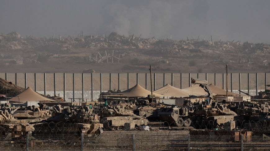 Israeli military vehicles sit along the border with Gaza, while smoke rises in the background, as seen from the Israeli side, September 3, 2025. REUTERS/Ammar Awad