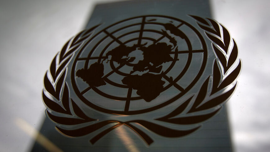 The United Nations headquarters building is pictured through a window with the UN logo in the foreground in the Manhattan borough of New York August 15, 2014. REUTERS/Carlo Allegri