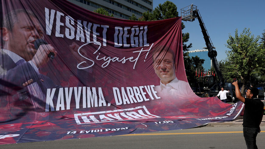 Workers hang a banner featuring images of main opposition Republican People's Party (CHP) leader Ozgur Ozel and jailed Istanbul Mayor Ekrem Imamoglu ahead of a rally, a day before a court is set to rule on whether to annul the party's last general congress and unseat its leader, in Ankara, Turkey, September 14, 2025. REUTERS/Umit Bektas