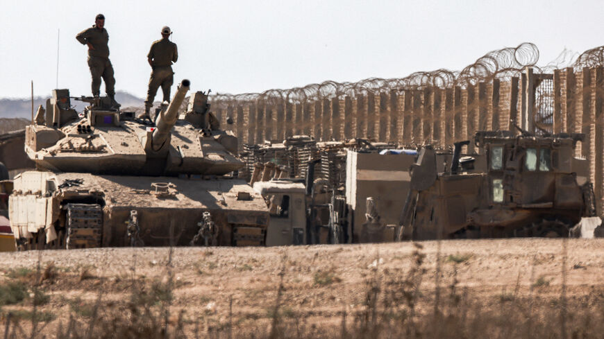 Israeli army soldiers stand atop the turret of a Merkava main battle tank positioned near armoured military bulldozers along the border with the Gaza Strip in southern Israel on Sept. 2, 2025.