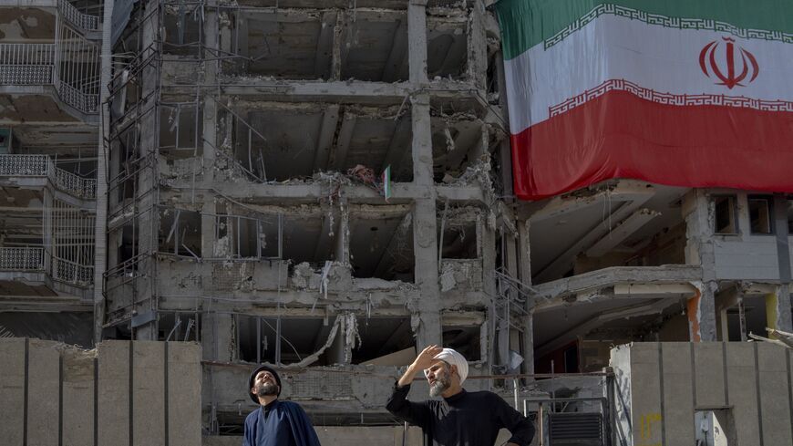 Two men look at houses destroyed in Israeli attacks, July 12, 2025, Tehran. (Majid Saeedi/Getty Images)