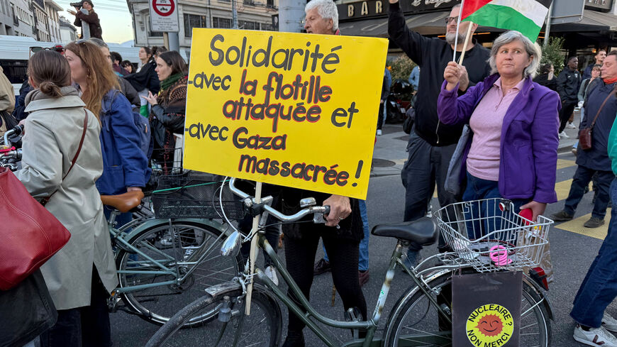 Pro-Palestinian demonstrators protest to condemn the Israeli forces', after Israel intercepted some of the vessels of the Global Sumud Flotilla aiming to reach Gaza and break Israel's naval blockade, in Geneva, Switzerland, October 2, 2025. The banner reads : Solidarity with attacked flotilla and massacred Gaza. REUTERS/Olivia Le Poidevin