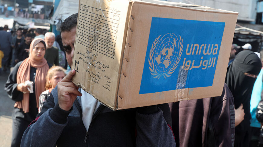 A Palestinian man carries an aid box distributed by the United Nations Relief and Works Agency (UNRWA), amid the Israel-Hamas conflict, in Deir Al-Balah, central Gaza Strip, November 4, 2024. REUTERS/Ramadan Abed