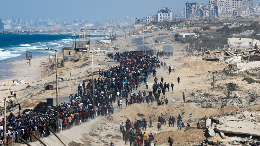 Palestinians, who were displaced to the southern part of Gaza at Israel's order during the war, walk along a road as they attempt to return to the north after a ceasefire between Israel and Hamas in Gaza went into effect, in the central Gaza Strip, October 10, 2025. REUTERS/Mahmoud Issa