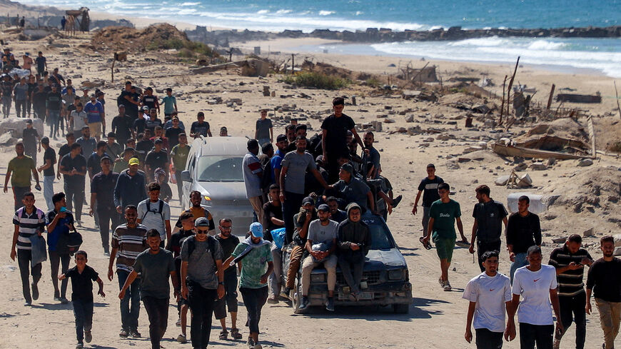 Palestinians, who were displaced to the southern part of Gaza at Israel's order during the war, make their way following their arrival in Gaza City after a ceasefire between Israel and Hamas in Gaza went into effect, October 10, 2025. REUTERS/Ebrahim Hajjaj
