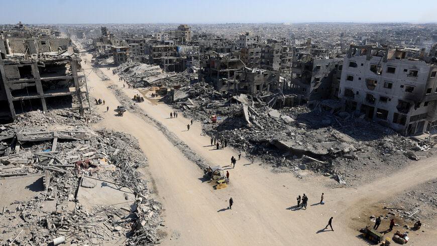 Palestinians walk past the rubble of destroyed buildings, amid a ceasefire between Israel and Hamas, in Gaza City, October 16, 2025. REUTERS/Dawoud Abu Alkas     TPX IMAGES OF THE DAY