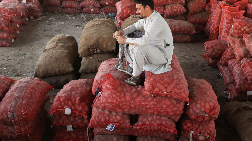 A man sits on sacks of potatoes at a wholesale vegetable market, as prices of various vegetables and fruits rose after Pakistan closed border crossings with Afghanistan following exchanges of fire, and a ceasefire deal was later agreed upon by the two nations, in Peshawar, Pakistan, October 23, 2025. REUTERS/Fayaz Aziz