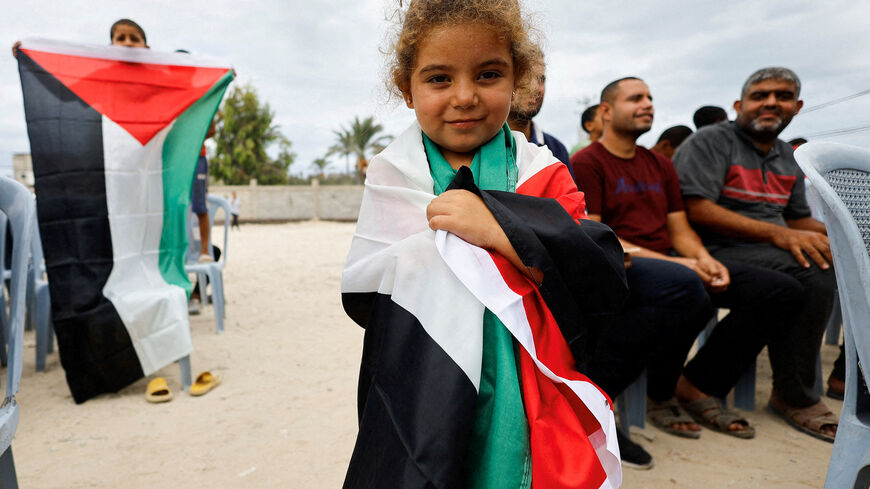 A girl holds a Palestinian flag, after it was announced that Israel and Hamas agreed on the first phase of a Gaza ceasefire, in the central Gaza Strip. REUTERS/Mahmoud Issa