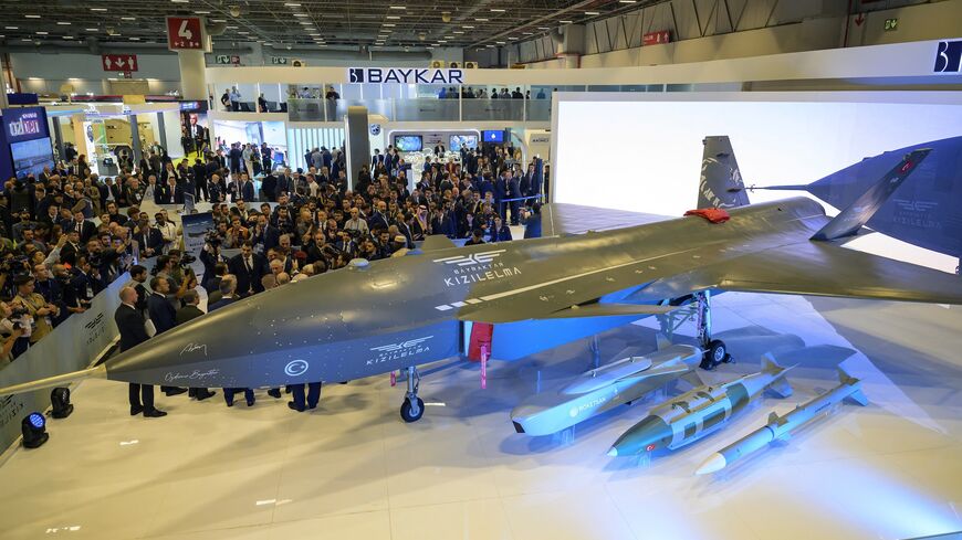Visitors stand looking at the Bayraktar Kizilelma UCAV at the International Defence and Aerospace exhibition in Istanbul on Oct. 22, 2024.