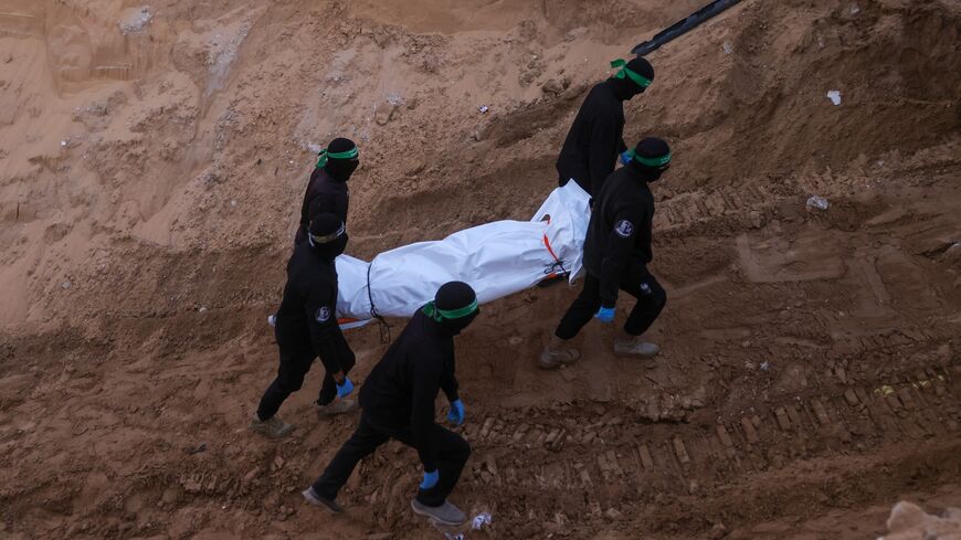 Hamas militants carry a body retrieved from a tunnel in an area north of Khan Yunis in the southern Gaza Strip, on Oct. 28, 2025.